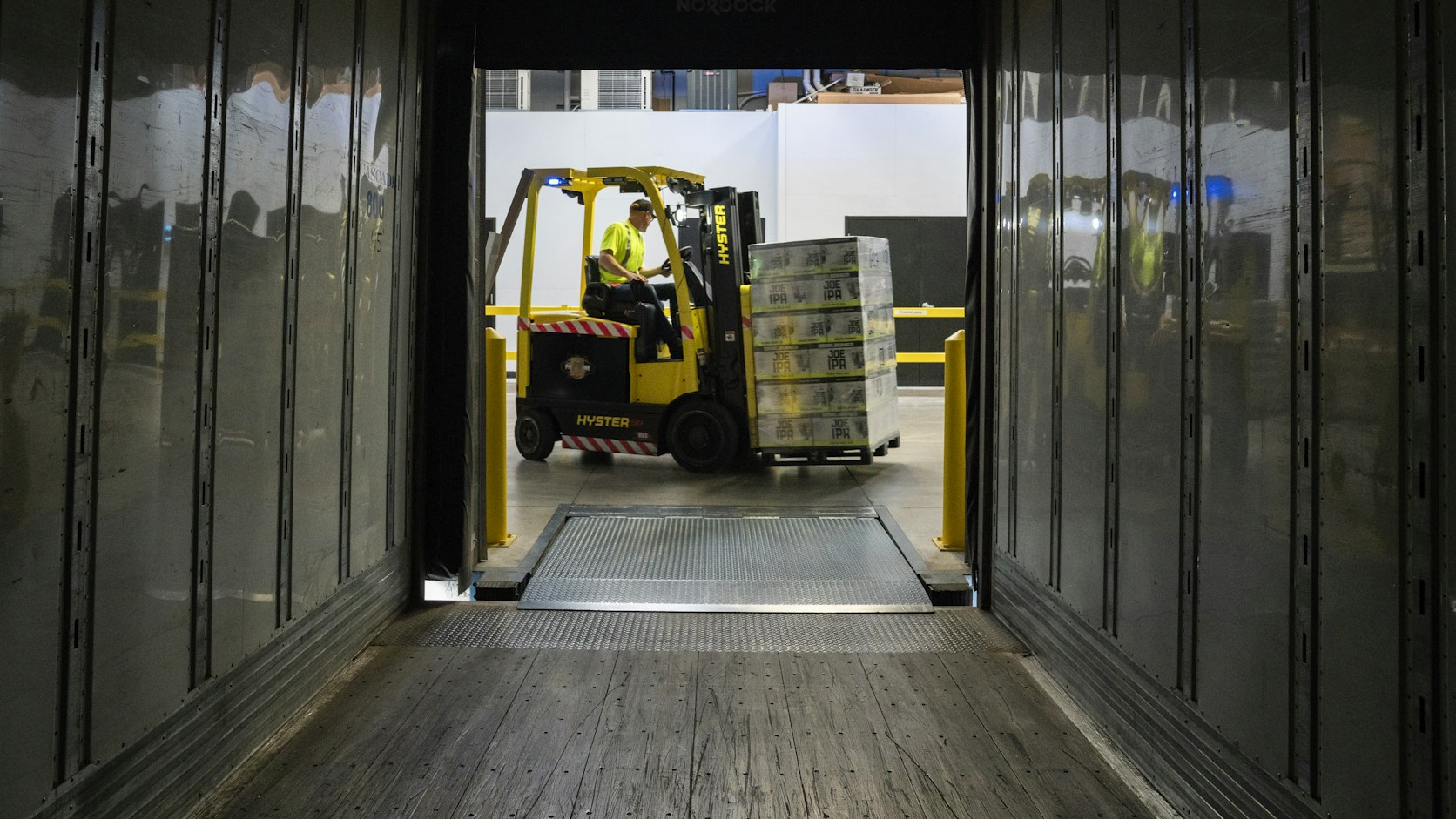 Forklift loading palletized cargo into a container